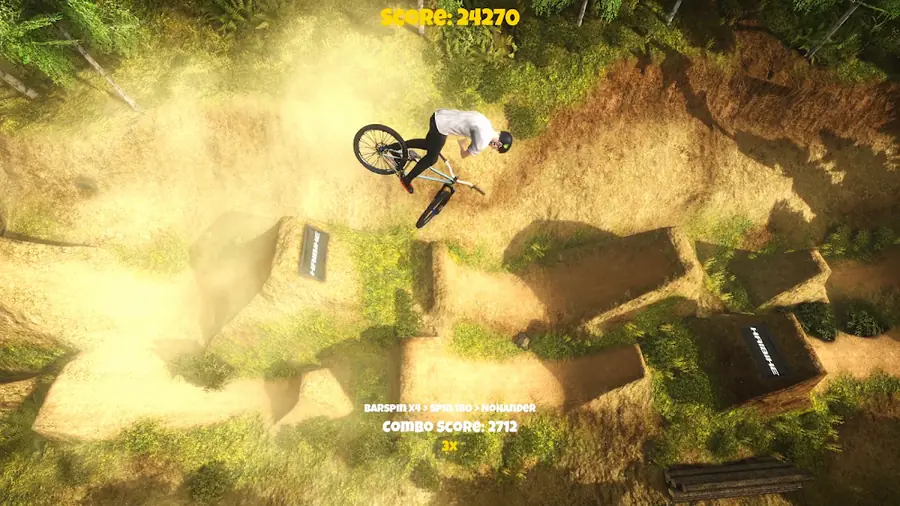 Ciclista de BTT em pleno salto sobre um trilho de terra numa floresta, no Shred! 2